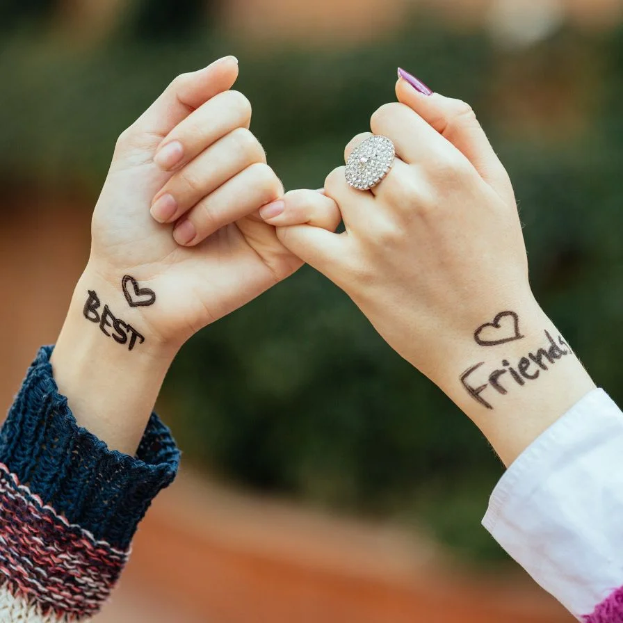 two-people-holding-hands-with-the-words-best-friends-written-on-their-hands