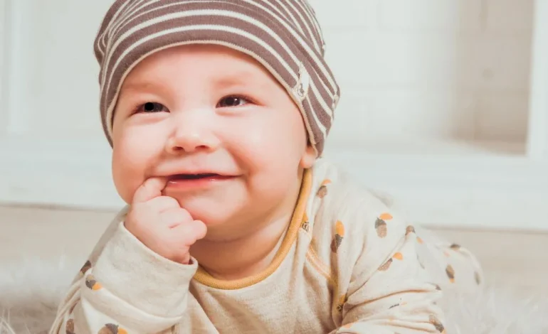 a baby in a hat laying on a white rug